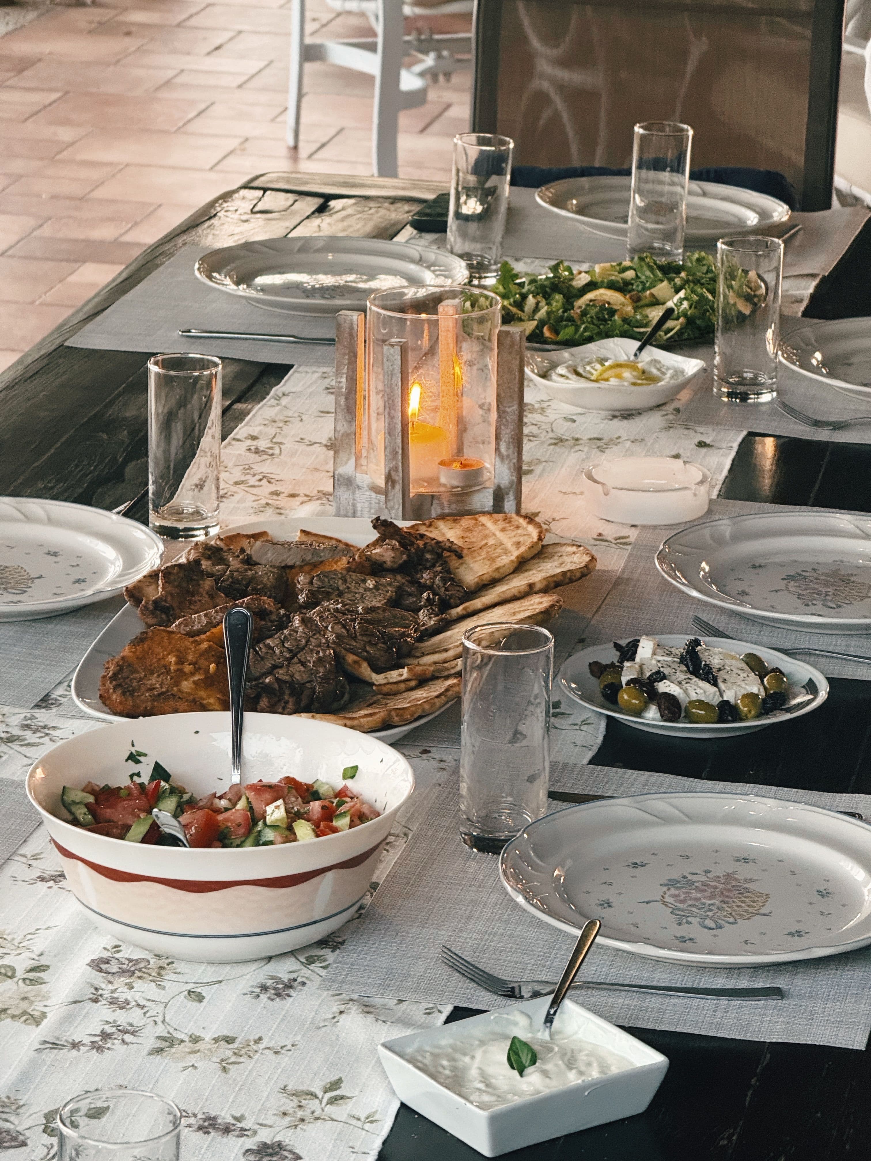 The same table at the end of the meal, with crumbs on the board and a spoon left in a dish