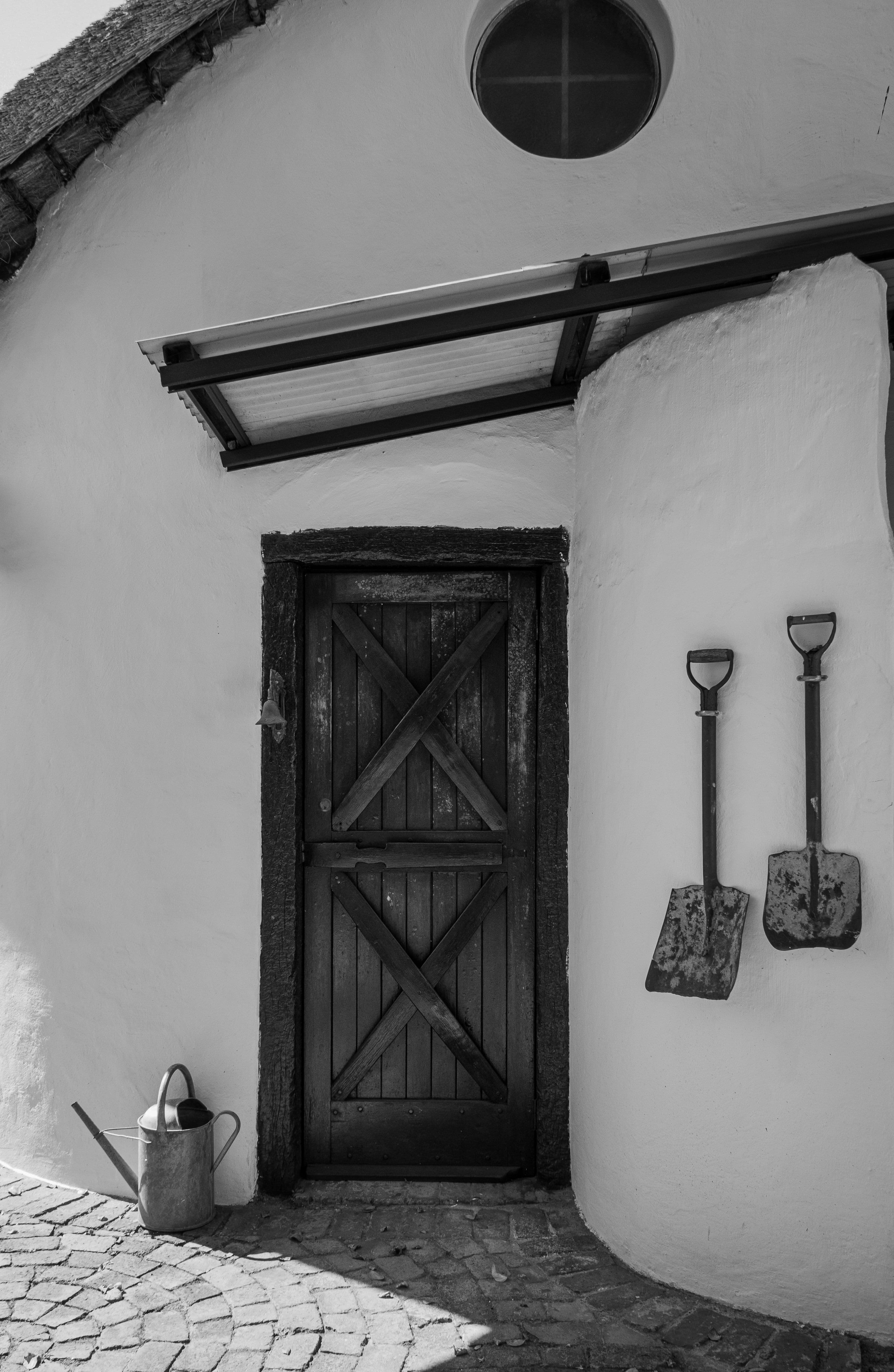 A small, well-kept collection of garden tools stored together in a natural garden setting
