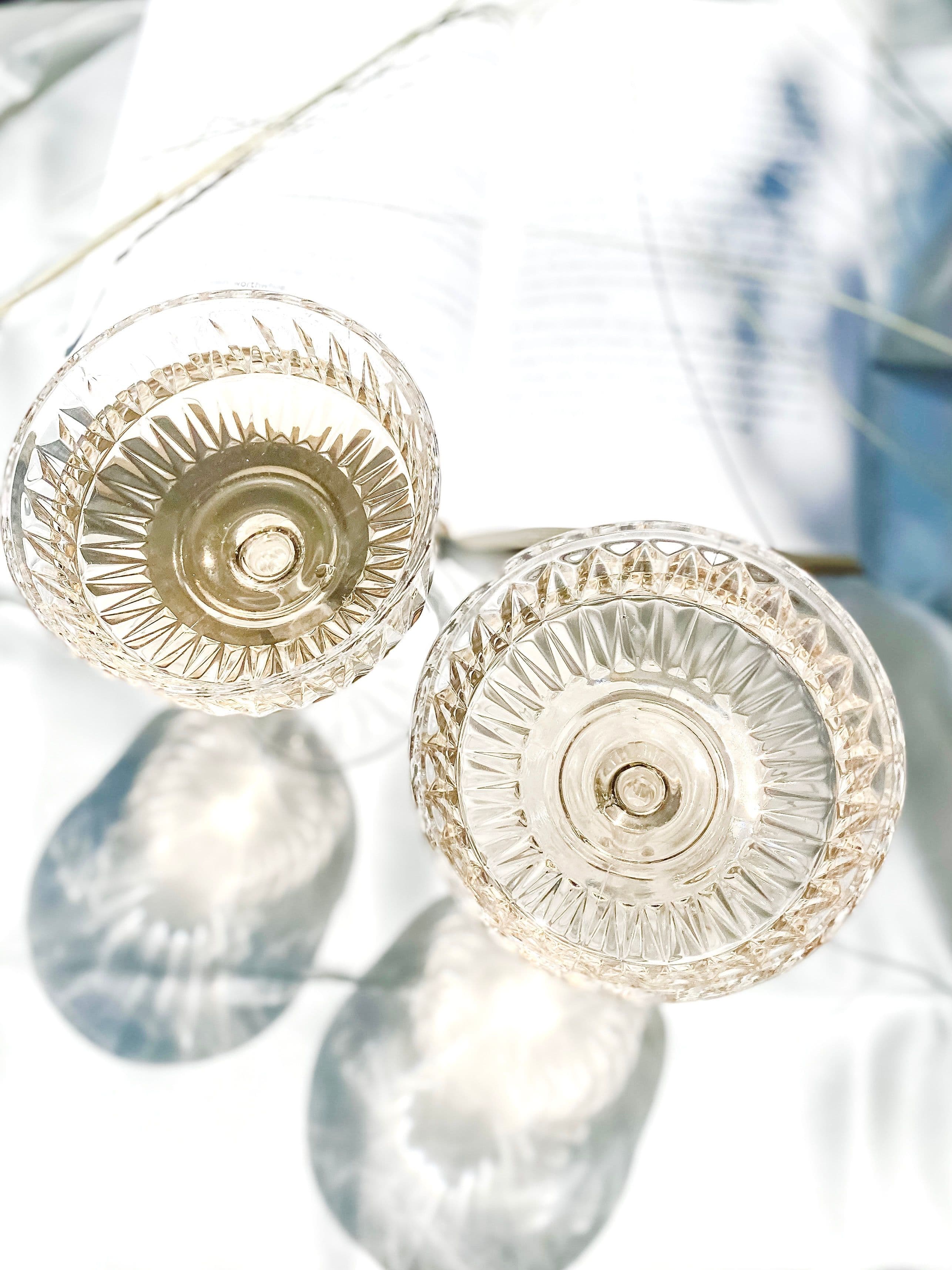 Close detail of a crystal glass rim and stem, with light passing through the bowl