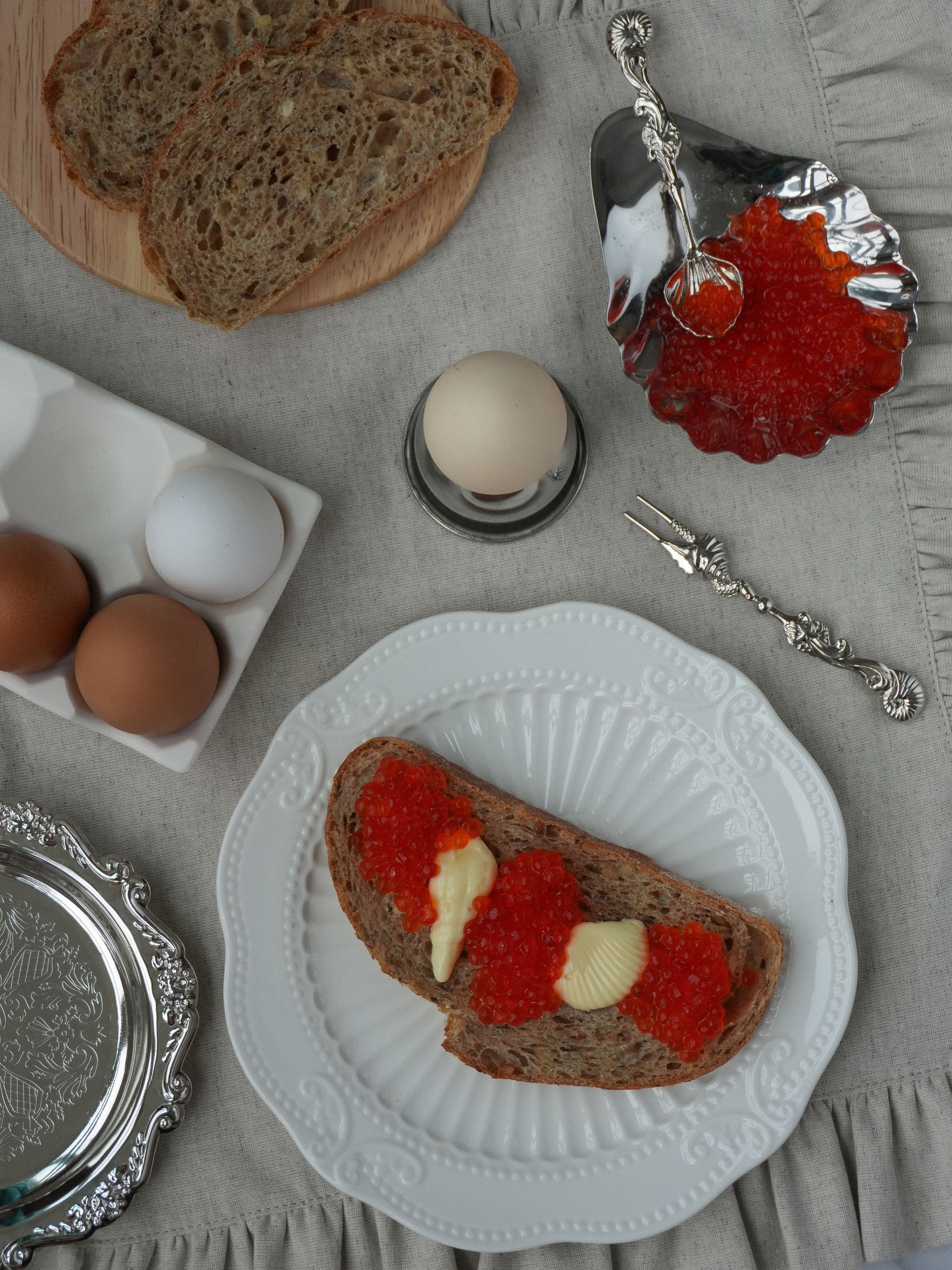 A well-used silver spoon and fork resting on a plate in natural light