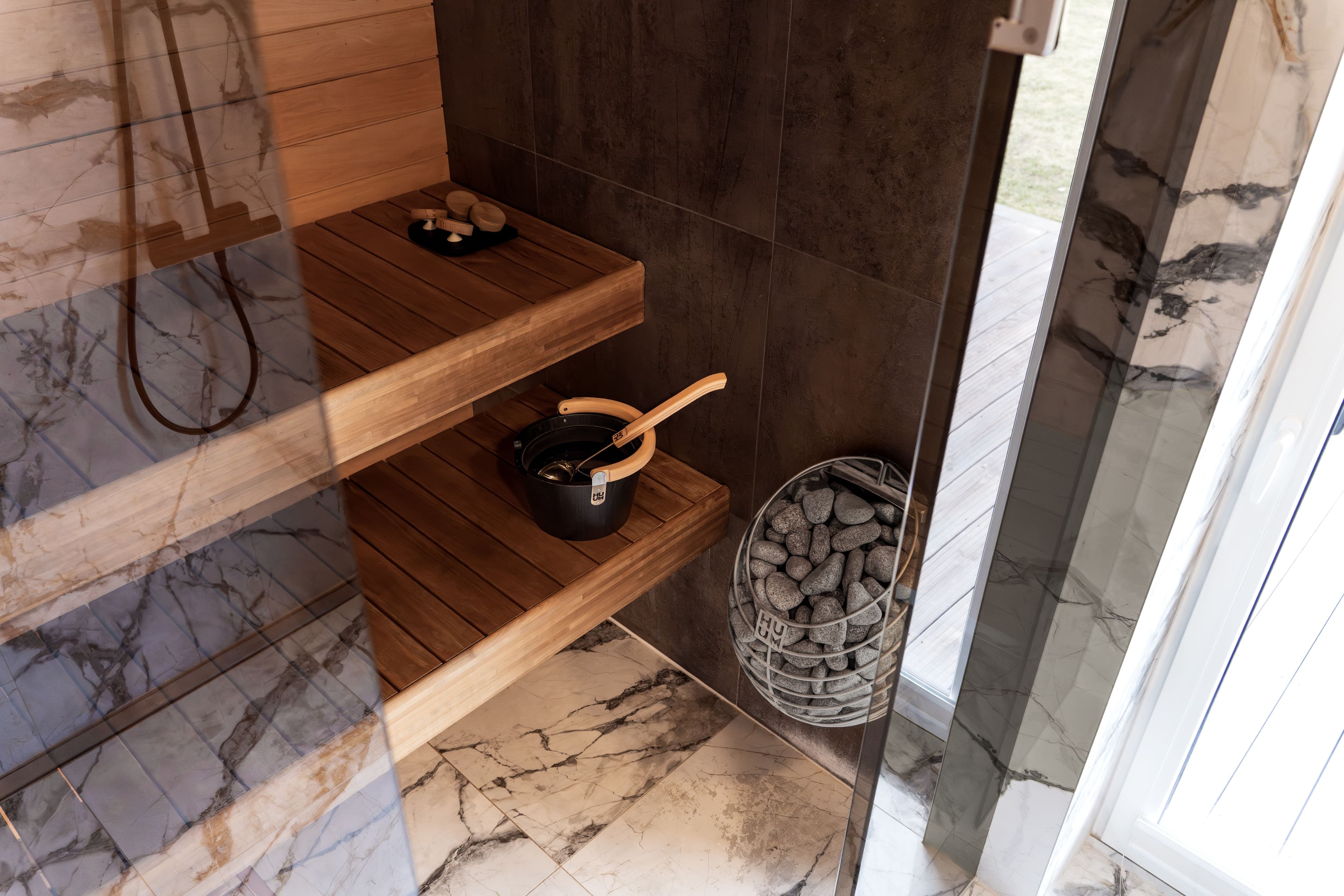 An empty sauna bench with folded linen towels, low light through a small window