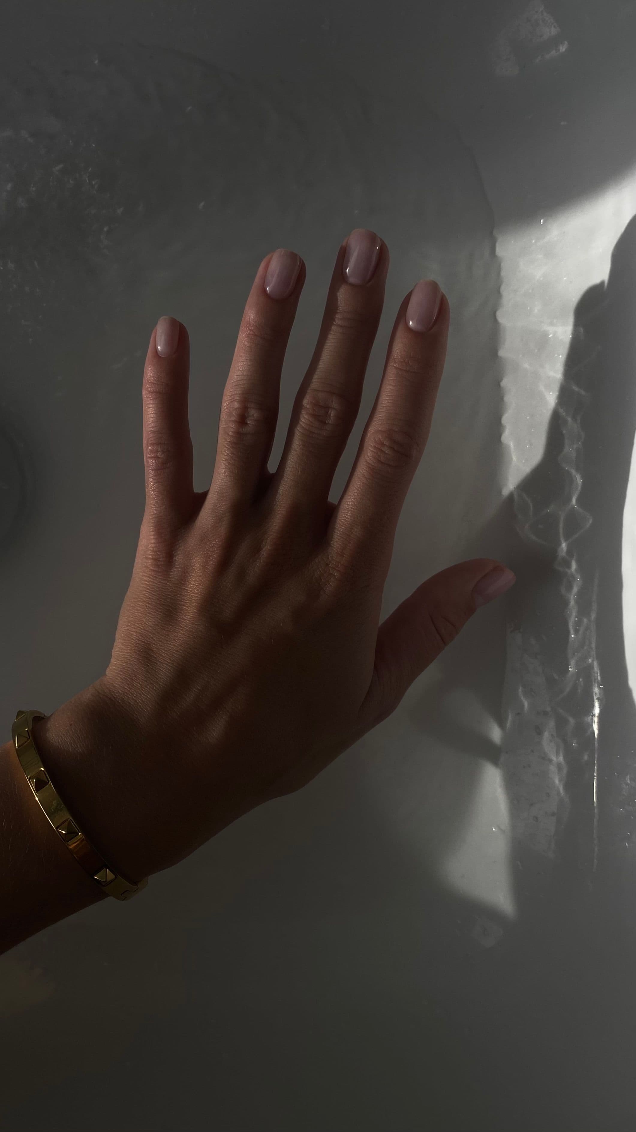 Close detail of a hand showing short, softly squared natural nails with clean edges