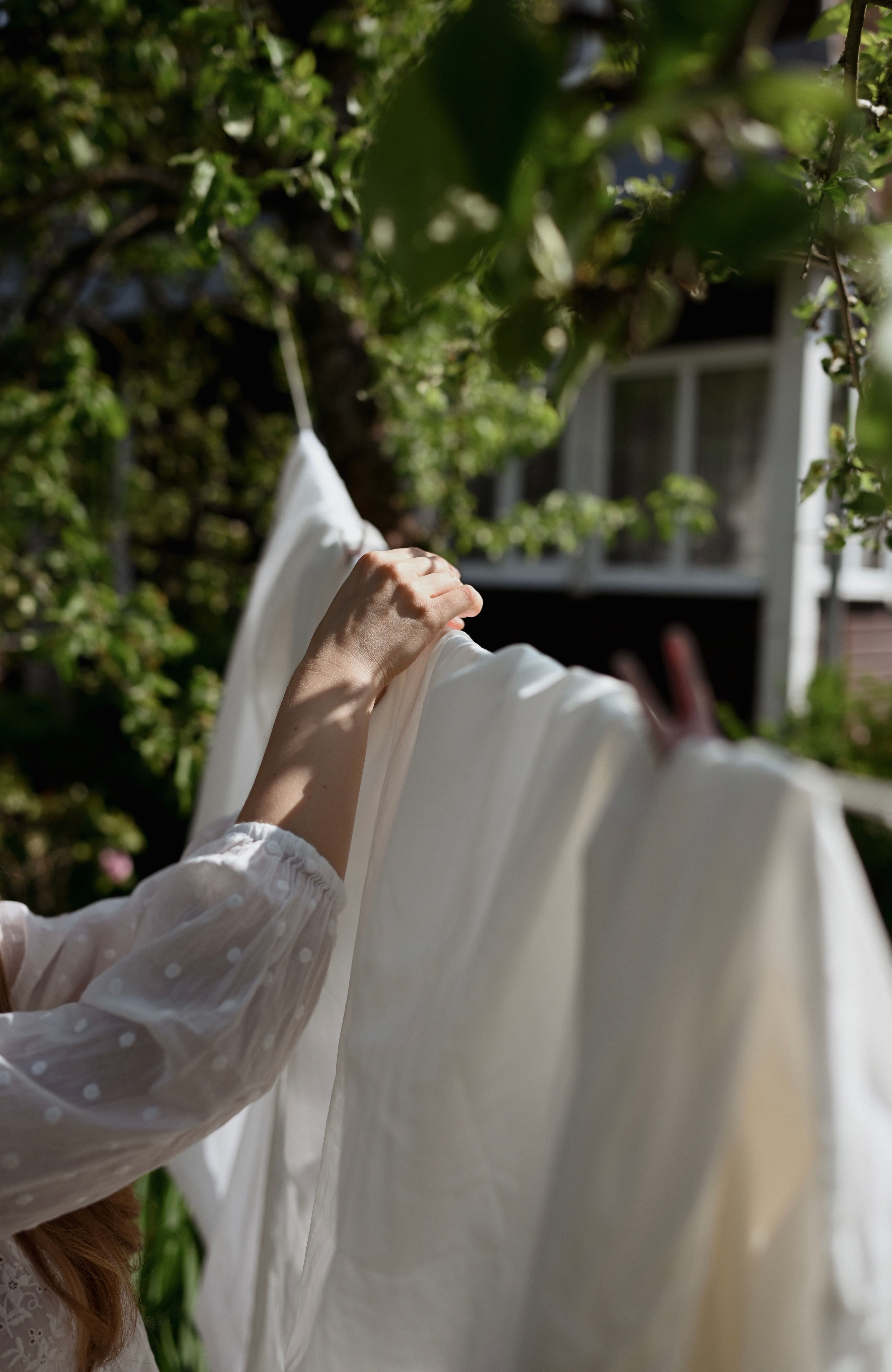 A white cotton shirt being folded after washing