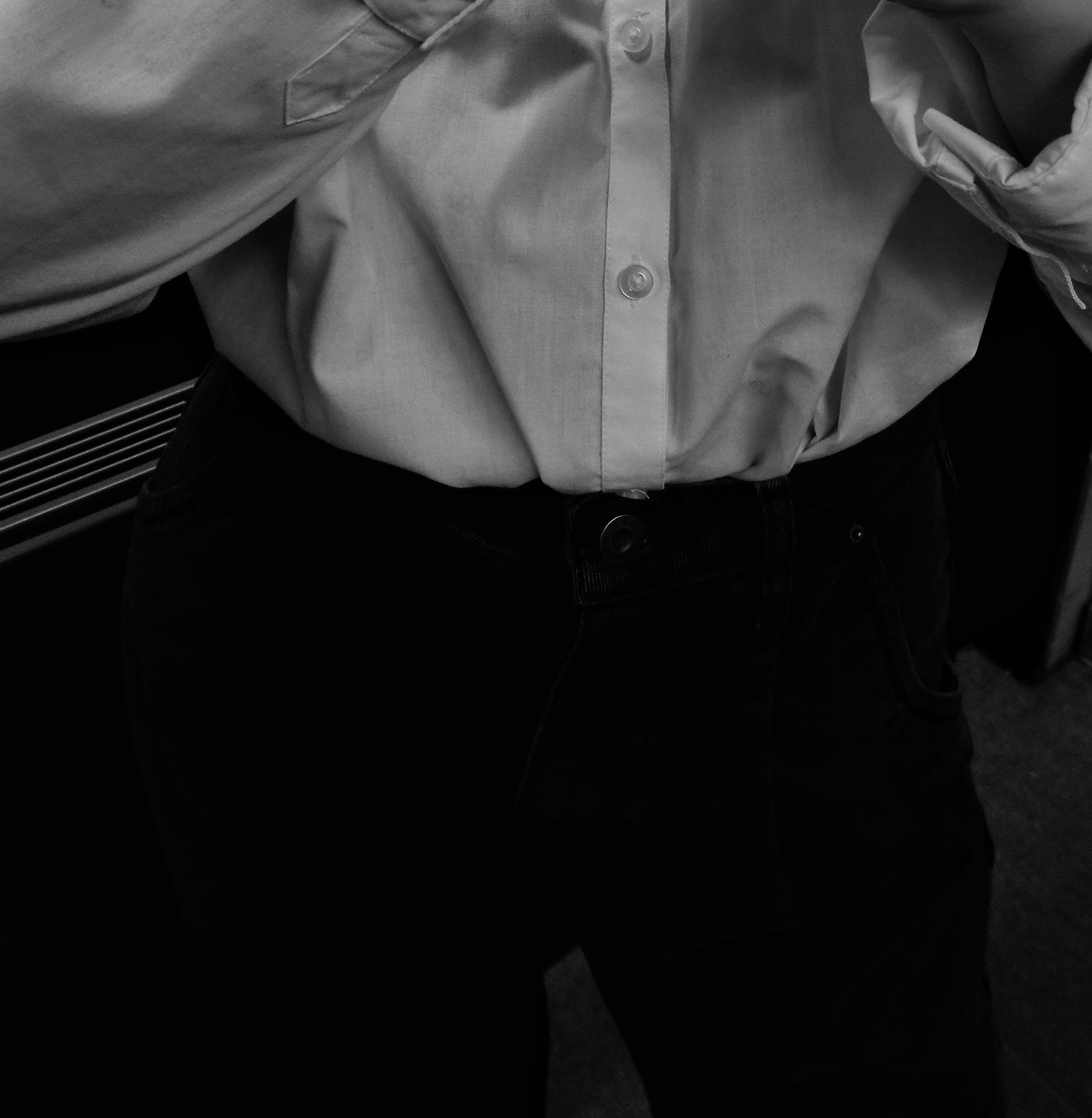 A white shirt worn with faded vintage denim, the cuffs turned back