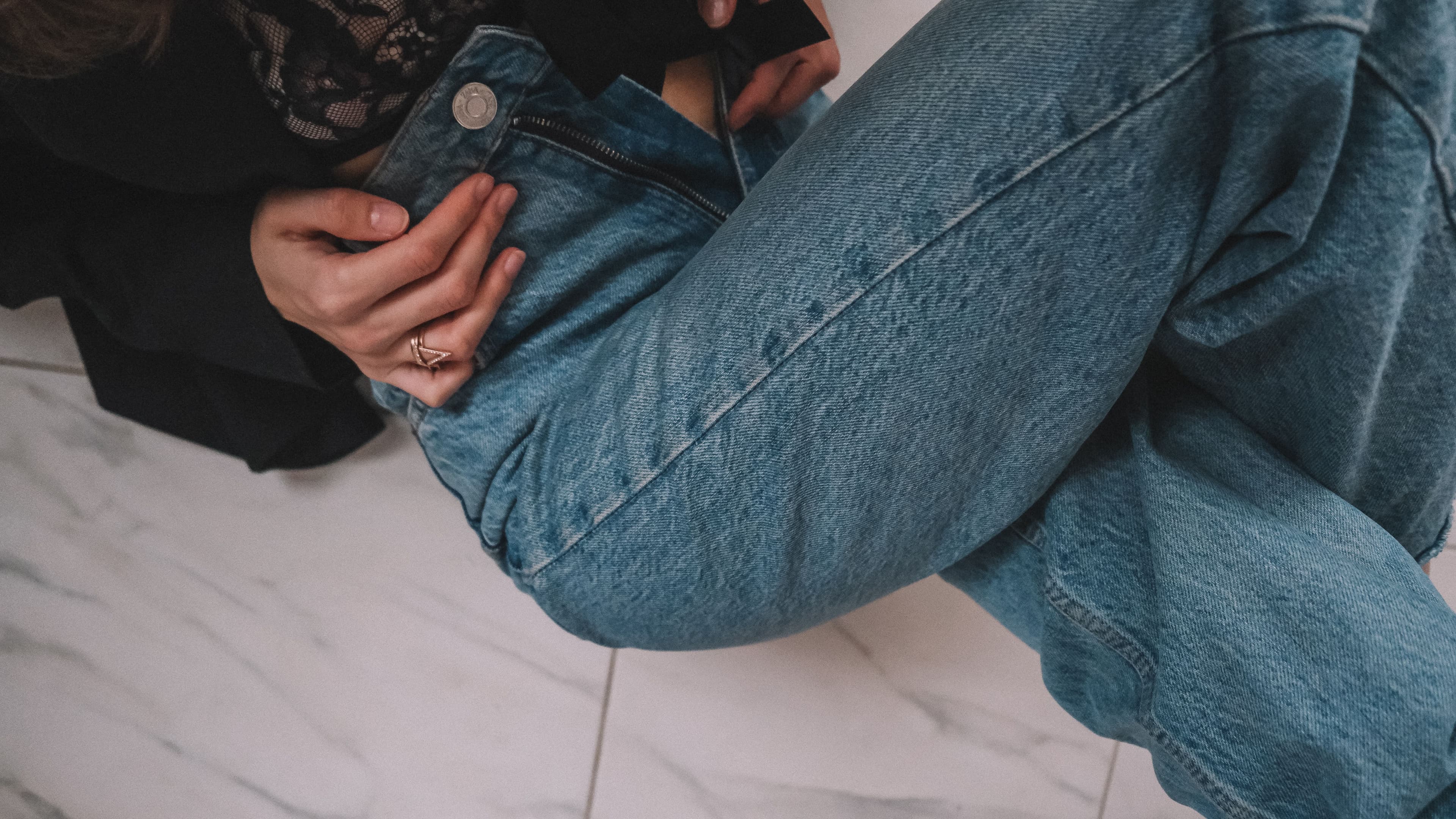 Close detail of faded blue denim showing softened cotton and paler wear along a seam