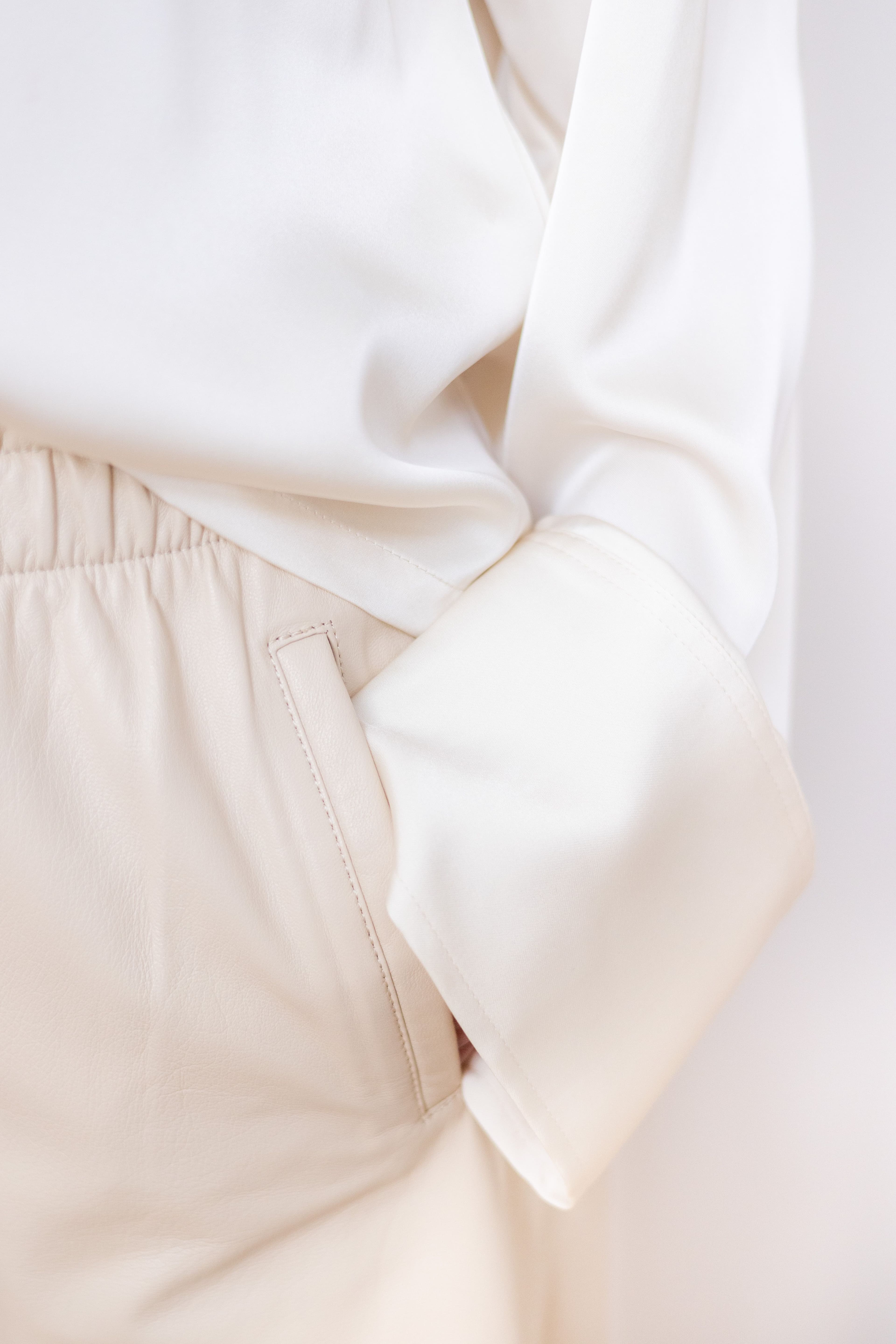 A trouser hem turned up and pinned, with tailor's chalk marks beside it